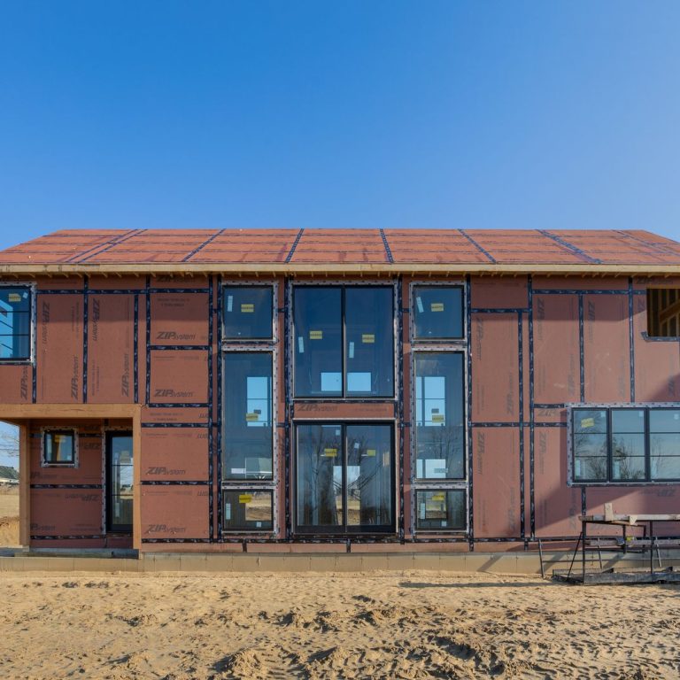 Custom Yankee Barn Home during framing and panel installation, showcasing early-stage construction in the build process
